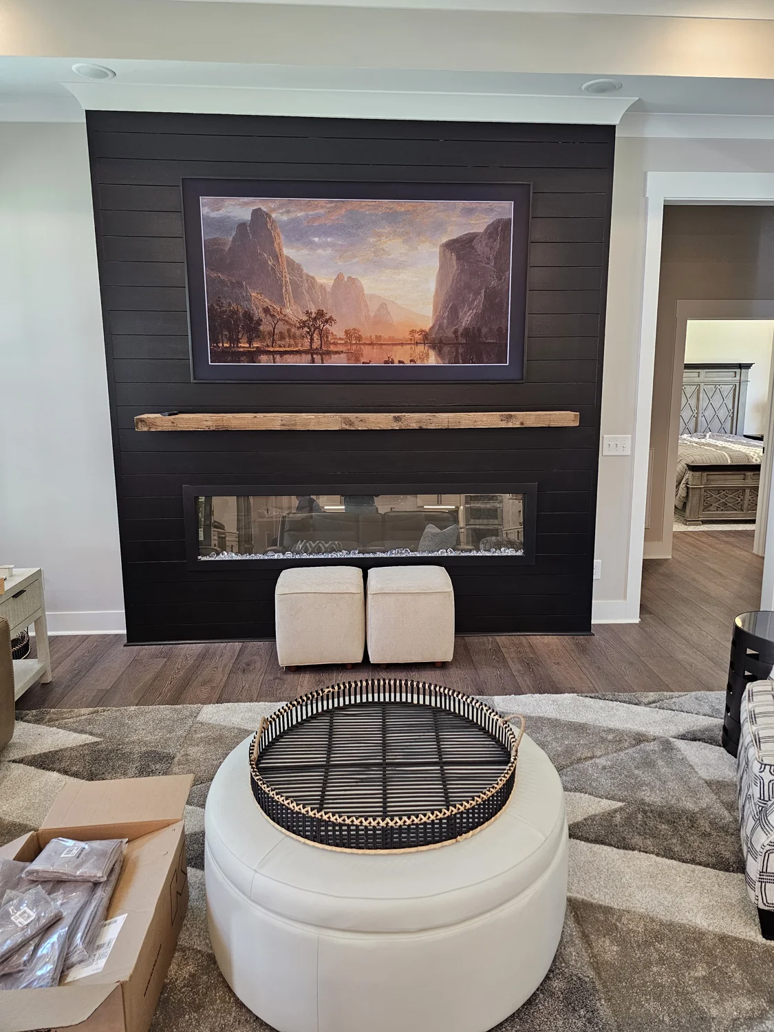 A Nice Guys framed-TV installation above a modern black fireplace