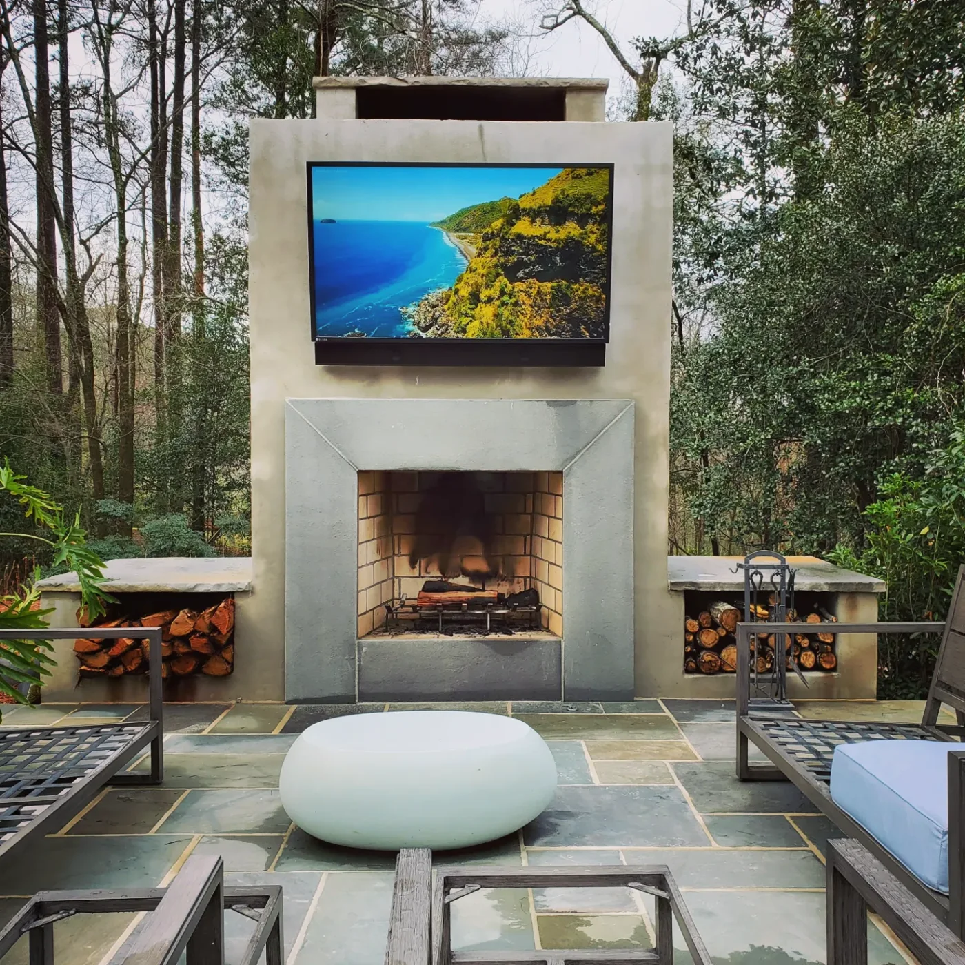 Outdoor TV visible above a patio fireplace