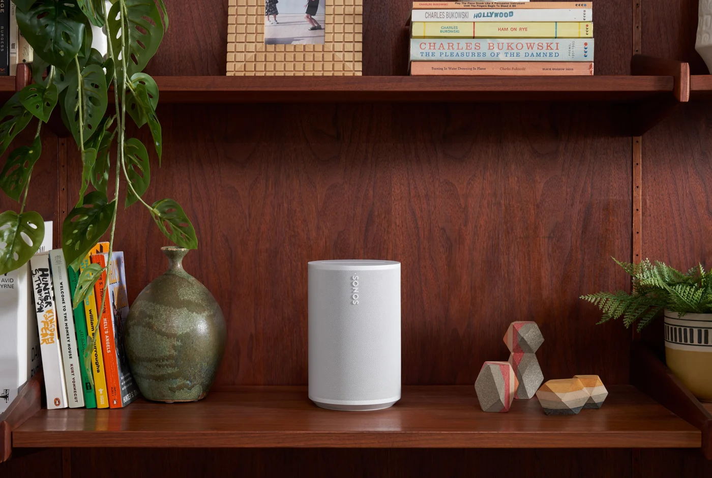 Sonos Era 100 speaker on a bookshelf