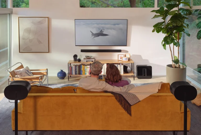 Sonos TV room with a soundbar below the screen, subwoofer beside the console and rear surrounds behind the sofa